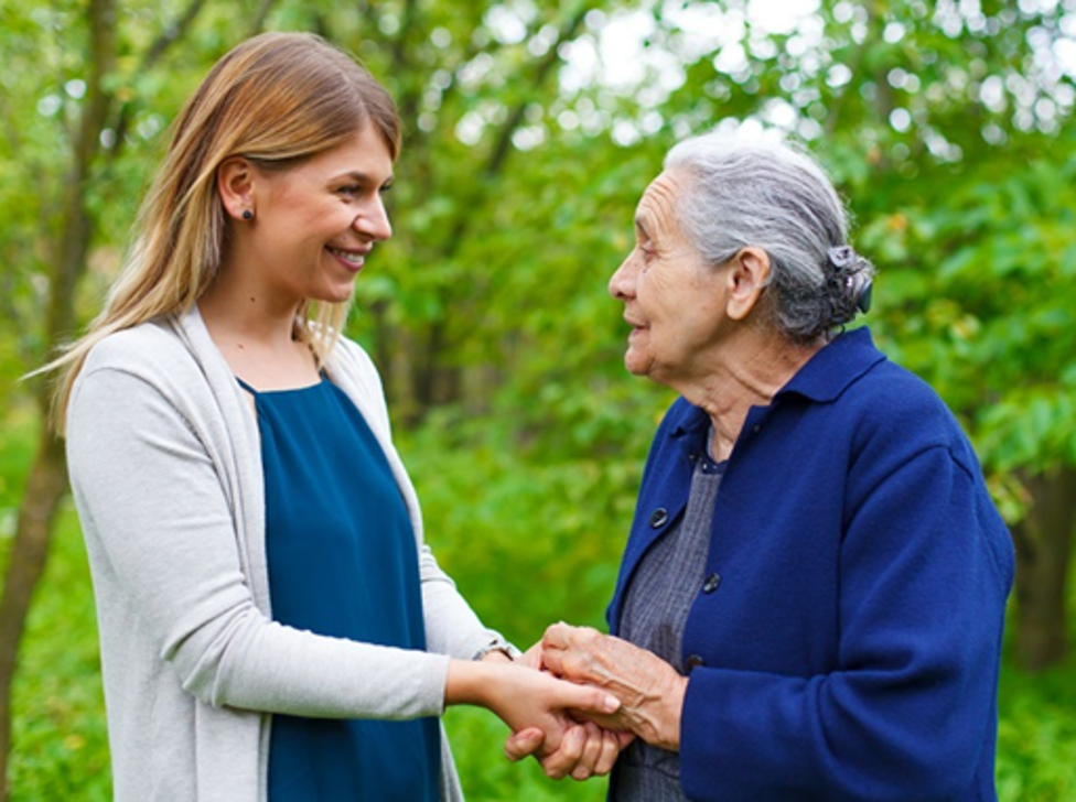 Young adult holding hands of senior