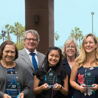 Smiling people holding awards